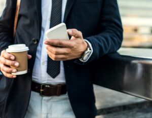 An English businessman holding an iPhone with a digital business card